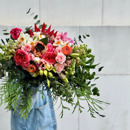 Big Bouquet of colorful flowers with greenery against a light background