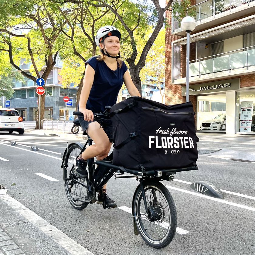 Elela Zhabreva CEO, florist and Courier from Florster riding a cargo bike delivering flowers and plants in Barcelona