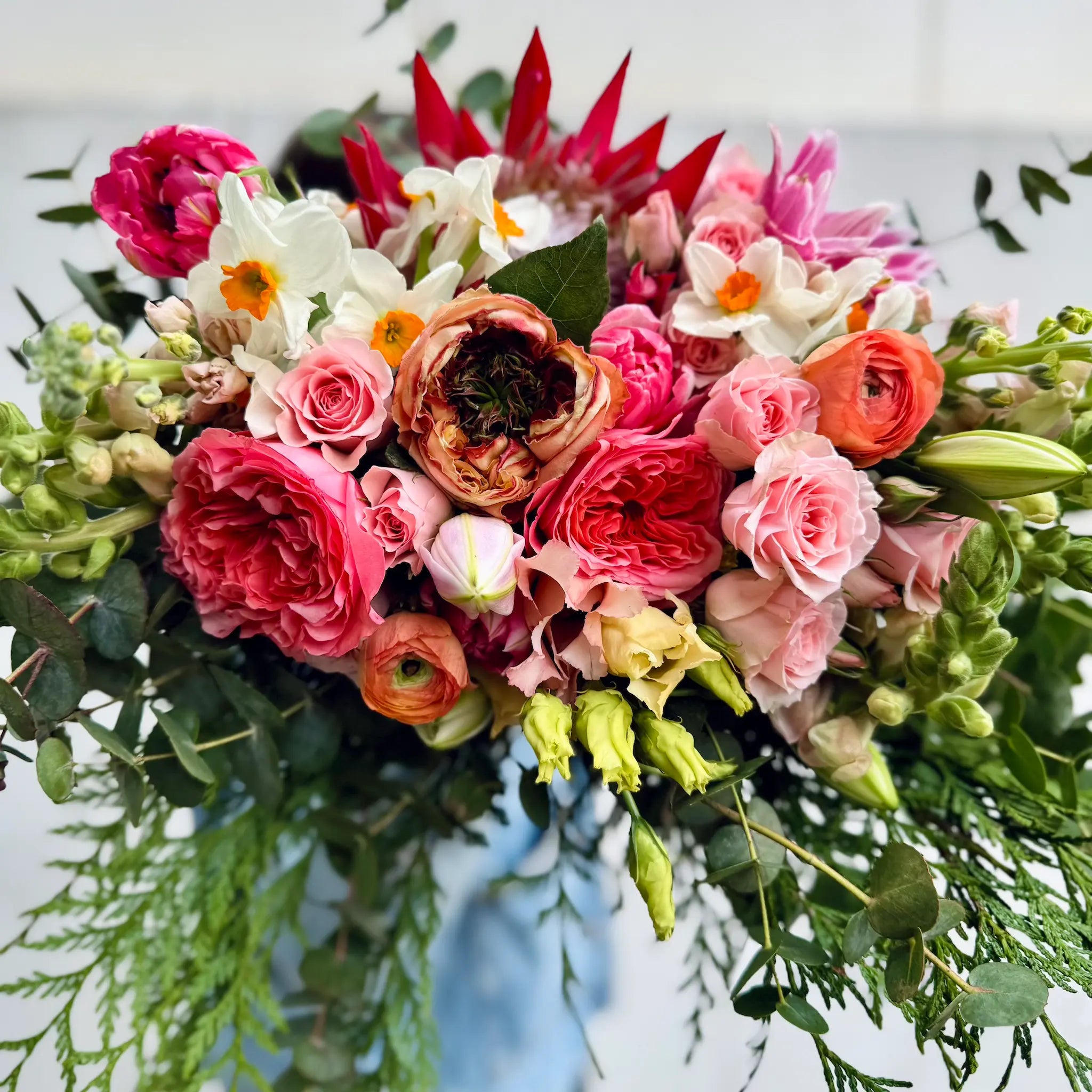 Bouquet of colorful flowers with pink, red, and white flowers on a light background