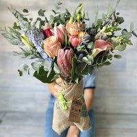 Small size bouquet with protea, roses, tulips and ranunculus. 